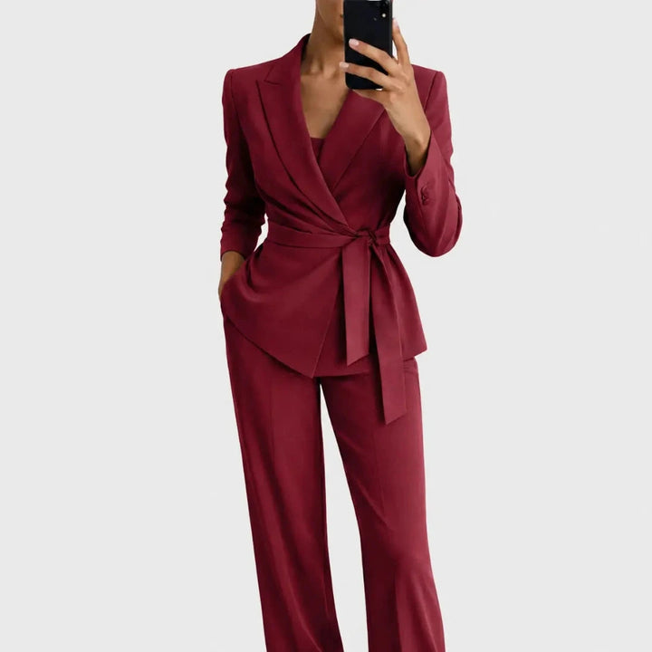 Même ensemble en version bordeaux, blazer croisé cintré par une ceinture nouée et pantalon large, porté de face. 5