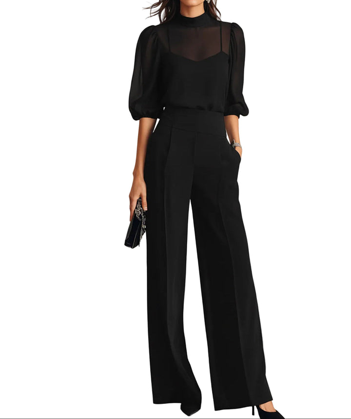 Ensemble noir porté par un mannequin sur fond blanc : haut transparent à manches bouffantes, caraco et pantalon large taille haute. 1