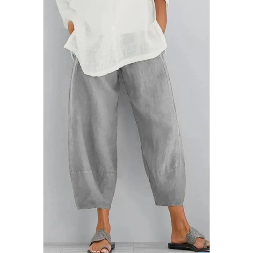Pantalon large gris clair à taille élastique, porté avec une blouse blanche et des sandales tressées sur fond gris. 4
