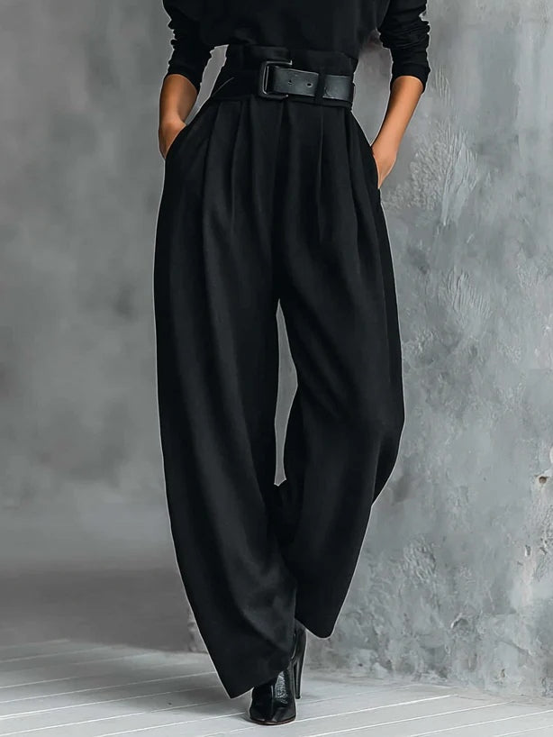 Détail du pantalon noir à jambes larges et plis marqués, taille haute ceinturée, porté avec des bottines 4