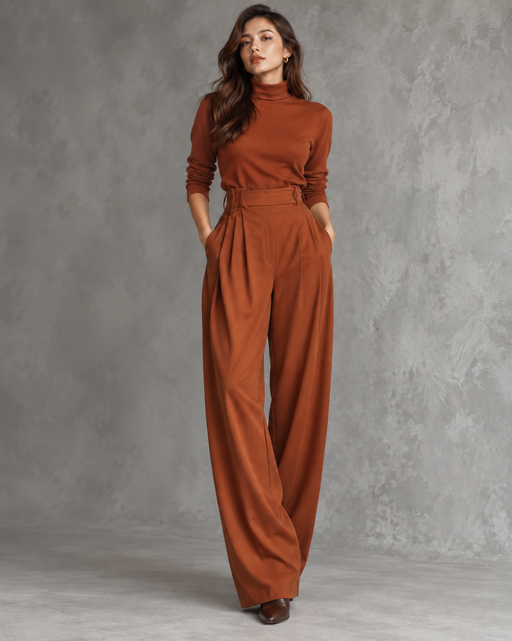 Mannequin aux cheveux longs portant l'ensemble couleur rouille, pantalon plissé à taille haute, sans ceinture, sur fond gris 8