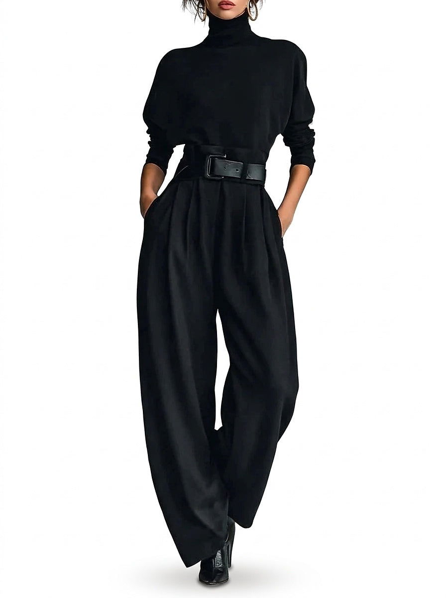 Mannequin de face en ensemble noir avec ceinture large en cuir, mains dans les poches, sur fond blanc 1