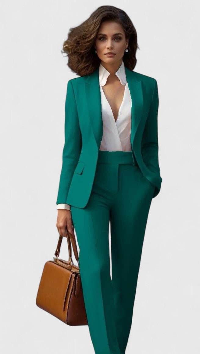 Femme en ensemble vert émeraude, blazer à revers sur chemisier blanc au col fantaisie, pantalon droit, sac marron. 4