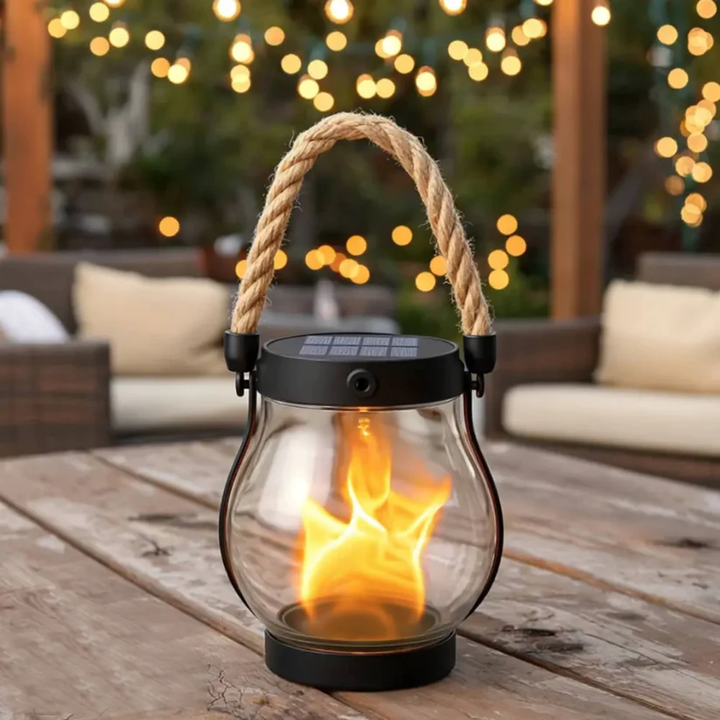 Lanterne en verre à anse en corde sur une table de terrasse, guirlandes lumineuses en fond 12