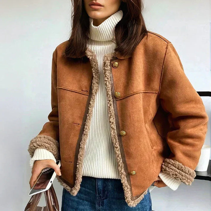 Femme portant la veste cognac ouverte sur un col roulé blanc, jean et sac à la main 1