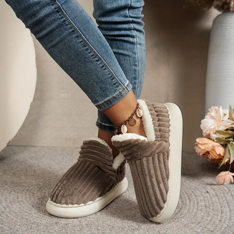 Chaussons marron côtelés portés avec un jean, jambes croisées, avec une bague de cheville et des fleurs en arrière-plan. 9