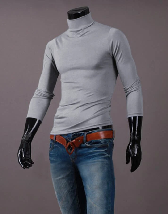 Haut gris clair à col montant porté sur un mannequin, avec jean bleu et ceinture marron 12