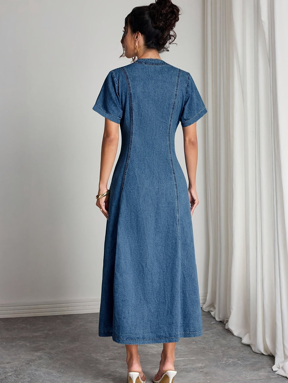 Vue de dos de la robe en denim à manches courtes, avec ses coutures verticales marquées 2