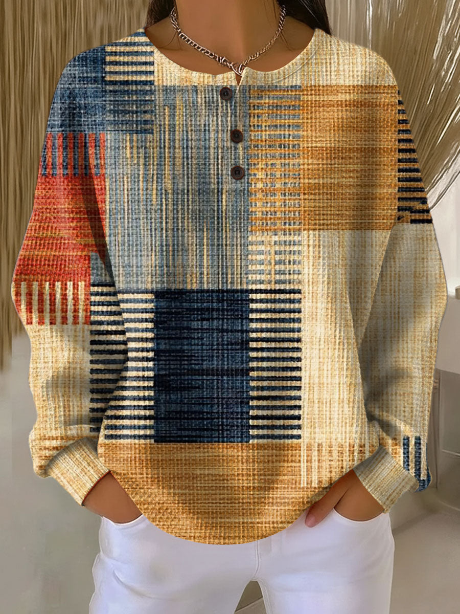 Pull gaufré à trois boutons, motif patchwork de rayures et blocs bleu marine, ocre, orange et rouge, vu de face. 3
