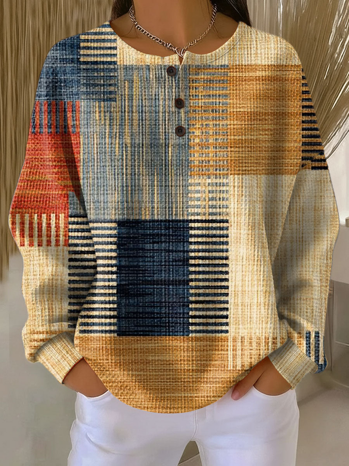 Pull gaufré à trois boutons, motif patchwork de rayures et blocs bleu marine, ocre, orange et rouge, vu de face. 3