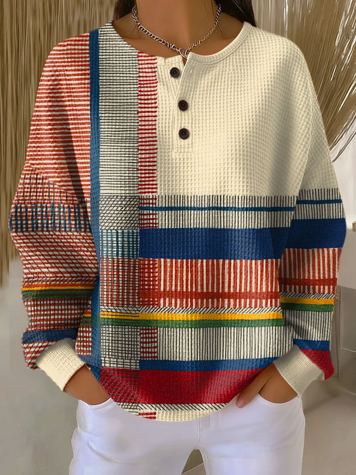 Pull gaufré beige à trois boutons, côté gauche en rayures colorées rouges, bleues, jaunes et vertes, vue de face. 6