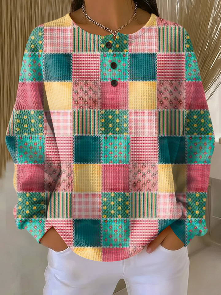 Pull gaufré à patchwork de carrés roses, verts, jaunes et turquoise, motifs fleuris et rayés, col à trois boutons. 20