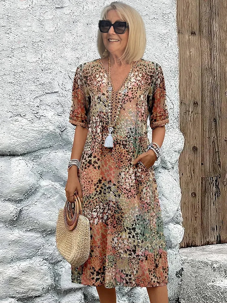 Robe à imprimé léopard multicolore dans des tons beige, orangé et vert, portée par une femme blonde en lunettes de soleil. 5