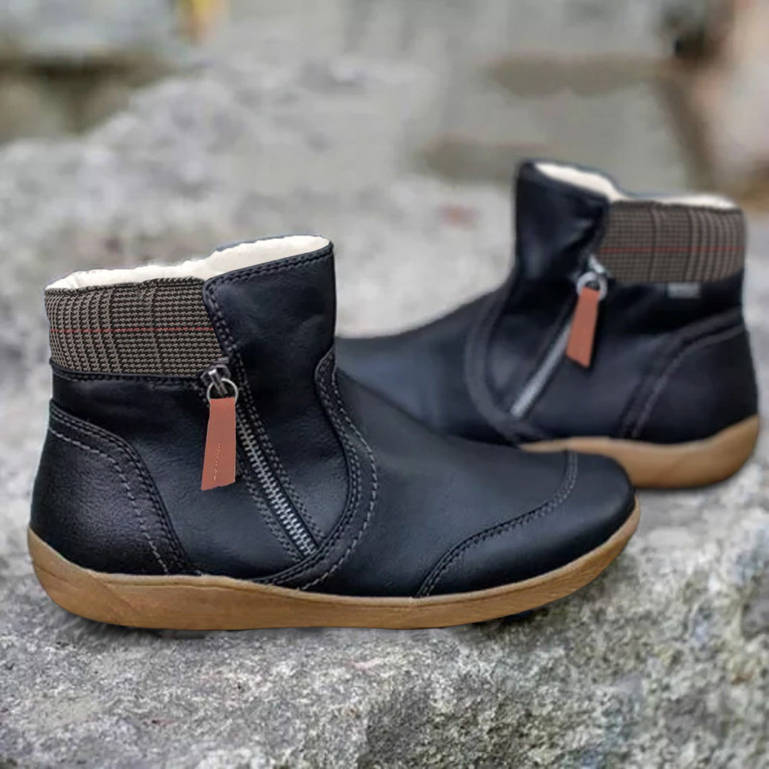Paire de bottines noires à fermeture éclair latérale avec languette marron, col doublé en tissu à carreaux, semelle beige. 2