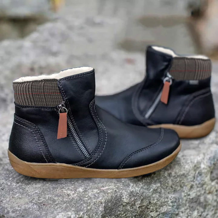 Paire de bottines noires à fermeture éclair latérale avec languette marron, col doublé en tissu à carreaux, semelle beige. 2