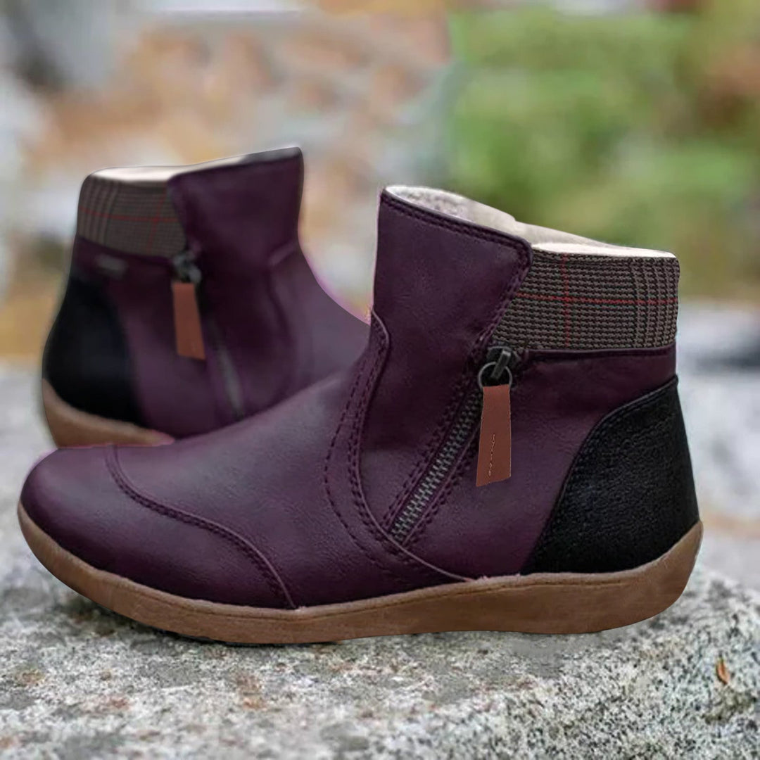Paire de bottines violet foncé avec zip latéral, col à carreaux et talon noir, posée sur une surface rocheuse. 4
