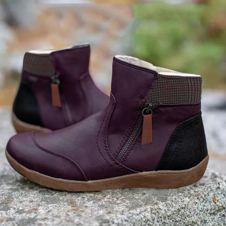 Paire de bottines violet foncé avec zip latéral, col à carreaux et talon noir, posée sur une surface rocheuse. 4