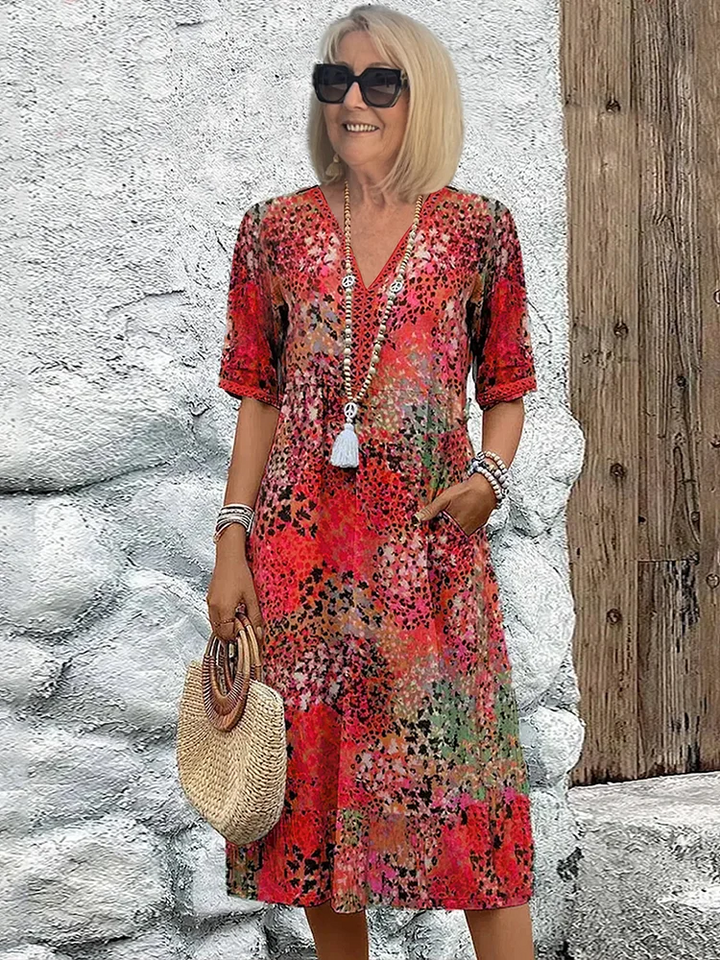 Femme blonde en lunettes de soleil portant la robe à col V et imprimé léopard rouge, sac en paille à la main. 1