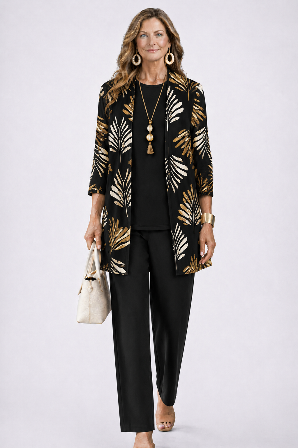 Femme en ensemble noir, cardigan ouvert à feuilles dorées et crème, haut uni et pantalon droit, sac beige. 5