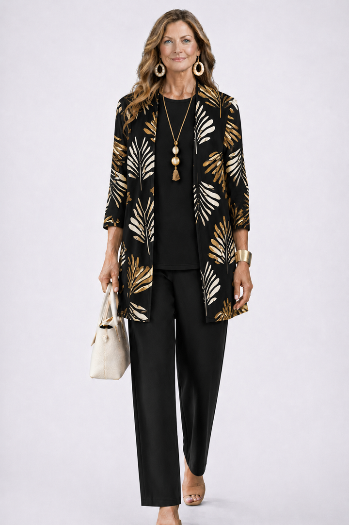 Femme en ensemble noir, cardigan ouvert à feuilles dorées et crème, haut uni et pantalon droit, sac beige. 5
