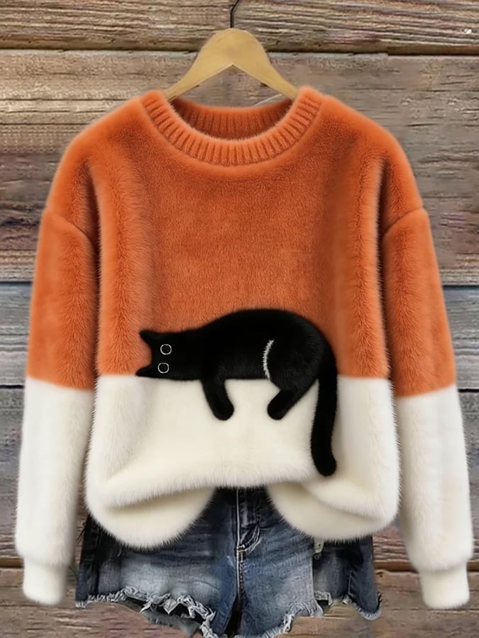 Pull duveteux orange et blanc orné d'un chat noir allongé, suspendu sur cintre 4
