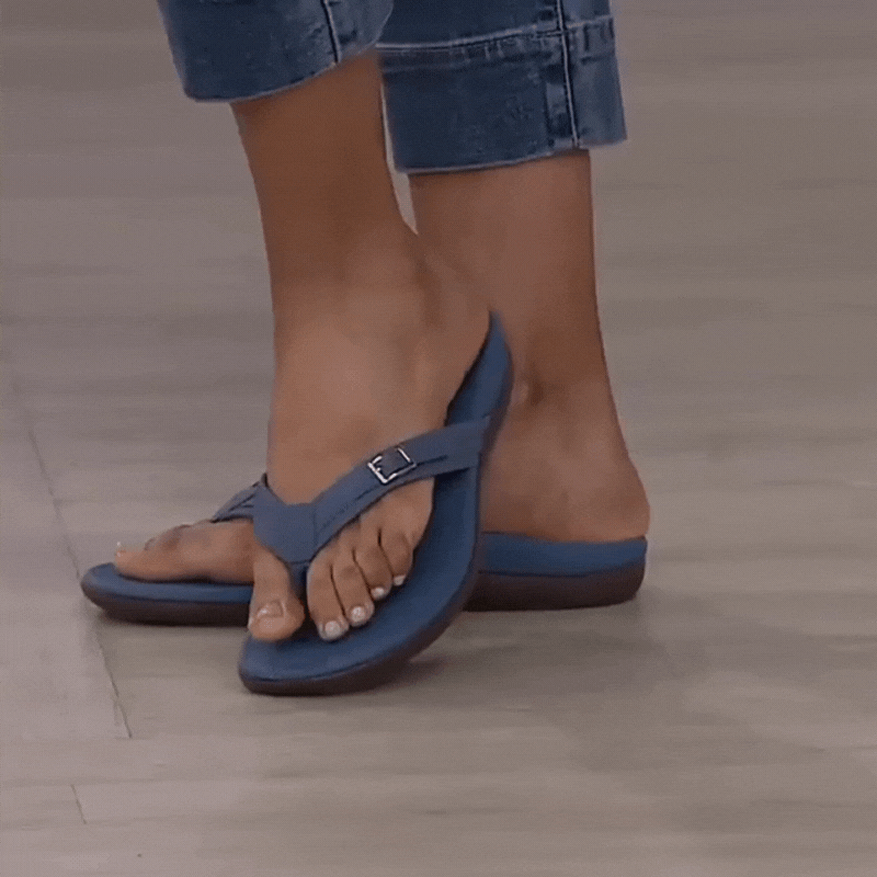 Tongs bleues à boucle portées par une femme en jean retroussé, vues de trois quarts 2