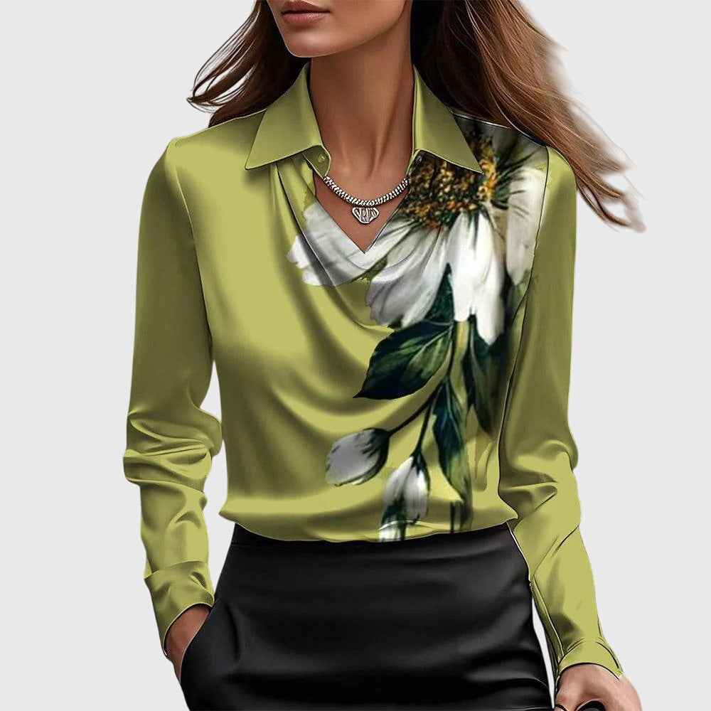 Blouse vert anis à col drapé avec grande fleur blanche et feuilles vertes imprimées sur le côté, portée avec jupe noire. 7