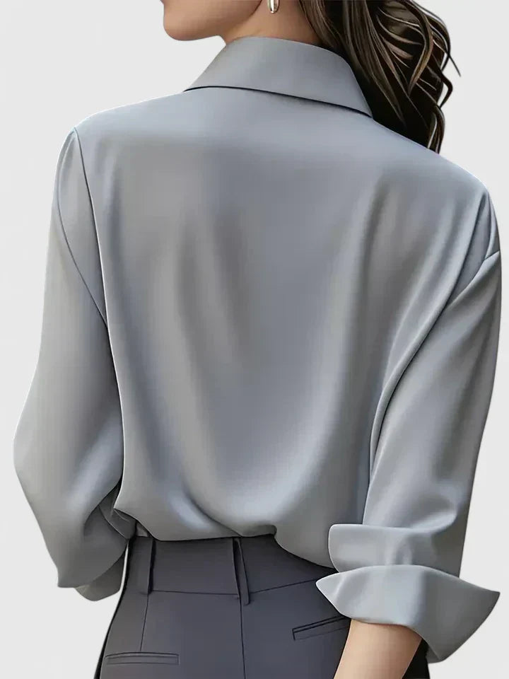 Vue de dos du chemisier gris clair, manche retroussée et col rabattu, porté avec un pantalon gris foncé. 8