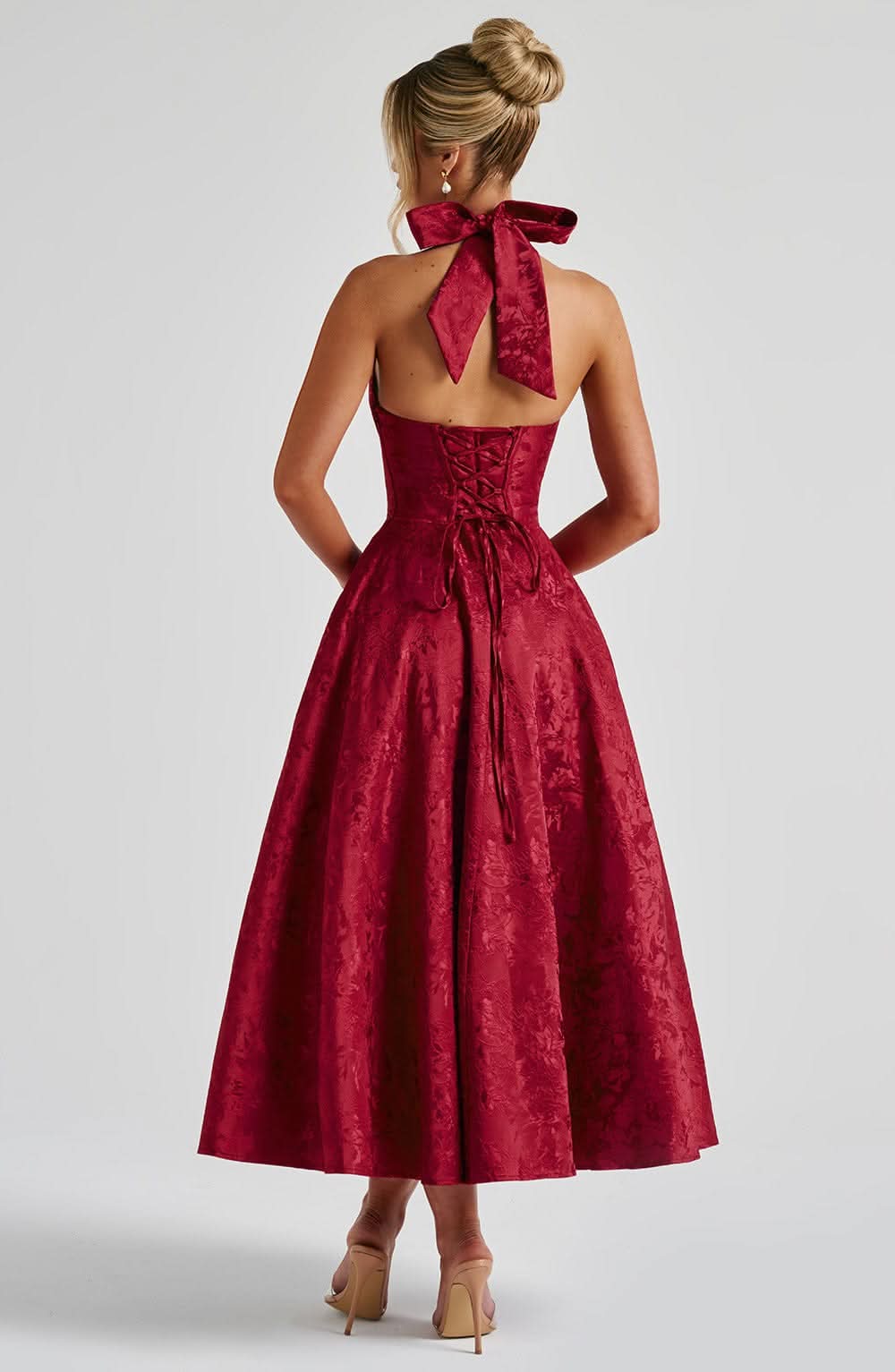 Dos de la robe rouge, avec nœud du col licou, dos ouvert, laçage corset et jupe évasée mi-longue. 11