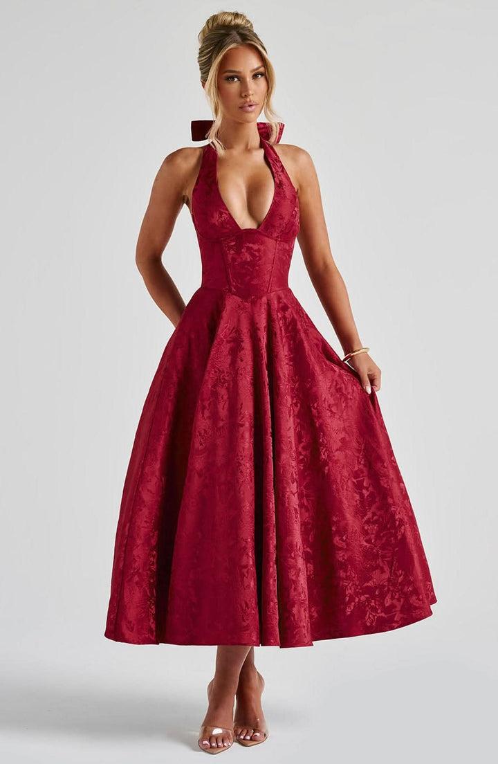 Robe rouge bordeaux à motif floral jacquard portée de face, col licou, taille corsetée et jupe très ample. 10