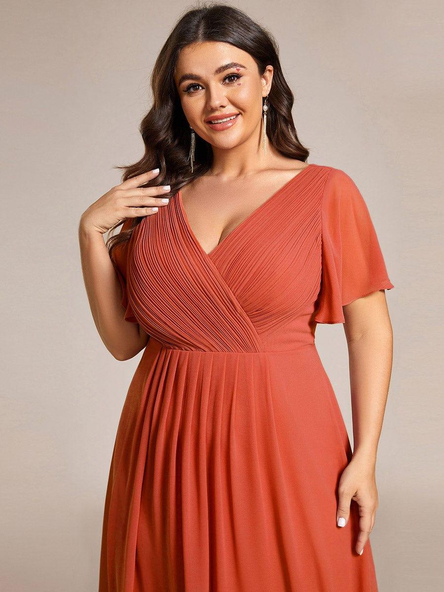 Gros plan sur le buste plissé croisé de la robe orange terracotta, mannequin grande taille souriante 99