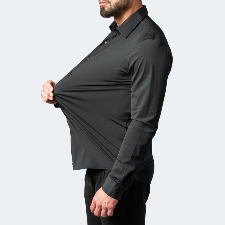 Chemise noire portée de profil, le tissu du ventre étiré à la main pour montrer sa grande extensibilité. 2