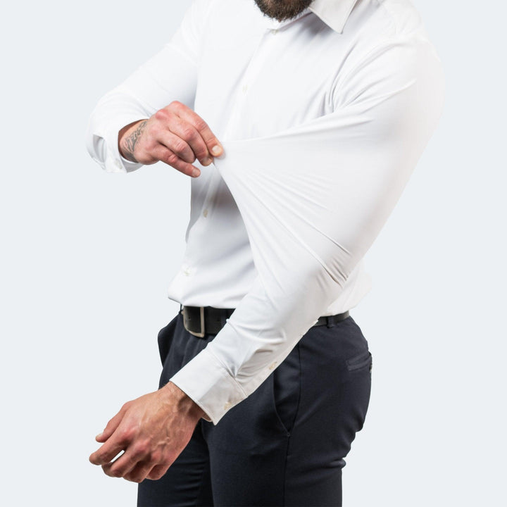 Chemise blanche portée avec pantalon sombre, la manche pincée et étirée pour montrer la souplesse du tissu. 4