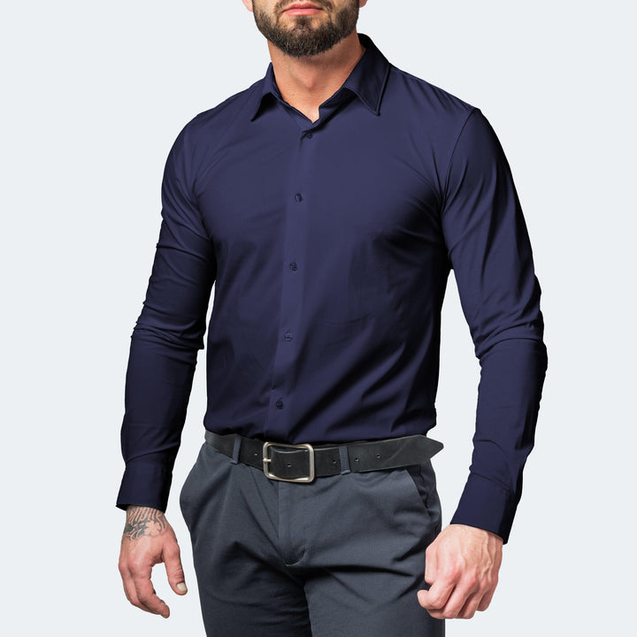 Homme barbu portant la chemise bleu marine boutonnée, avec pantalon gris et ceinture noire, vue de face. 5