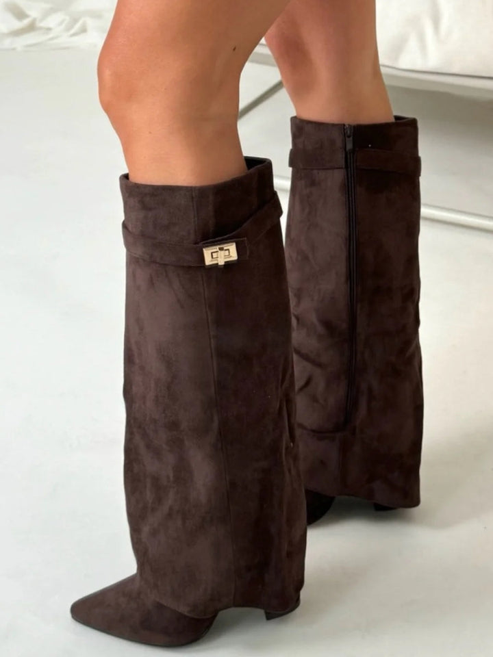 Détail des bottes marron foncé en daim portées debout, avec la boucle dorée sur le devant et le zip visible à l'arrière. 9