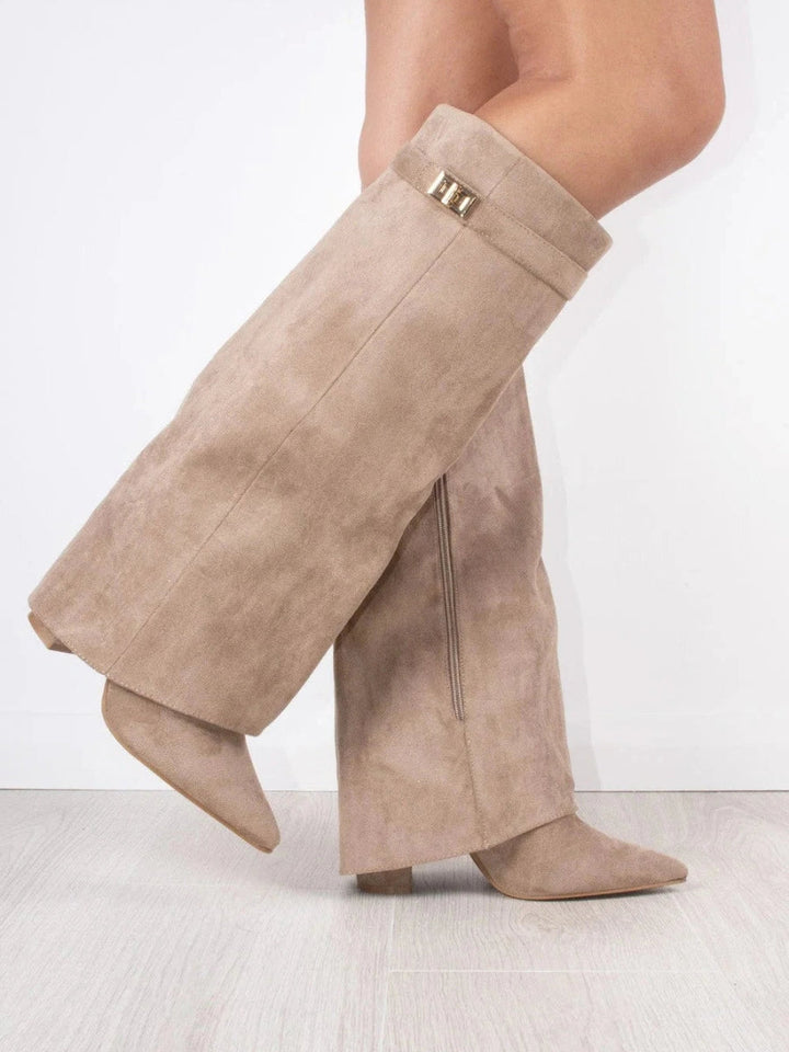 Bottes beige en daim portées en marchant, vue de trois quarts avec boucle dorée, zip latéral et talon bloc. 13