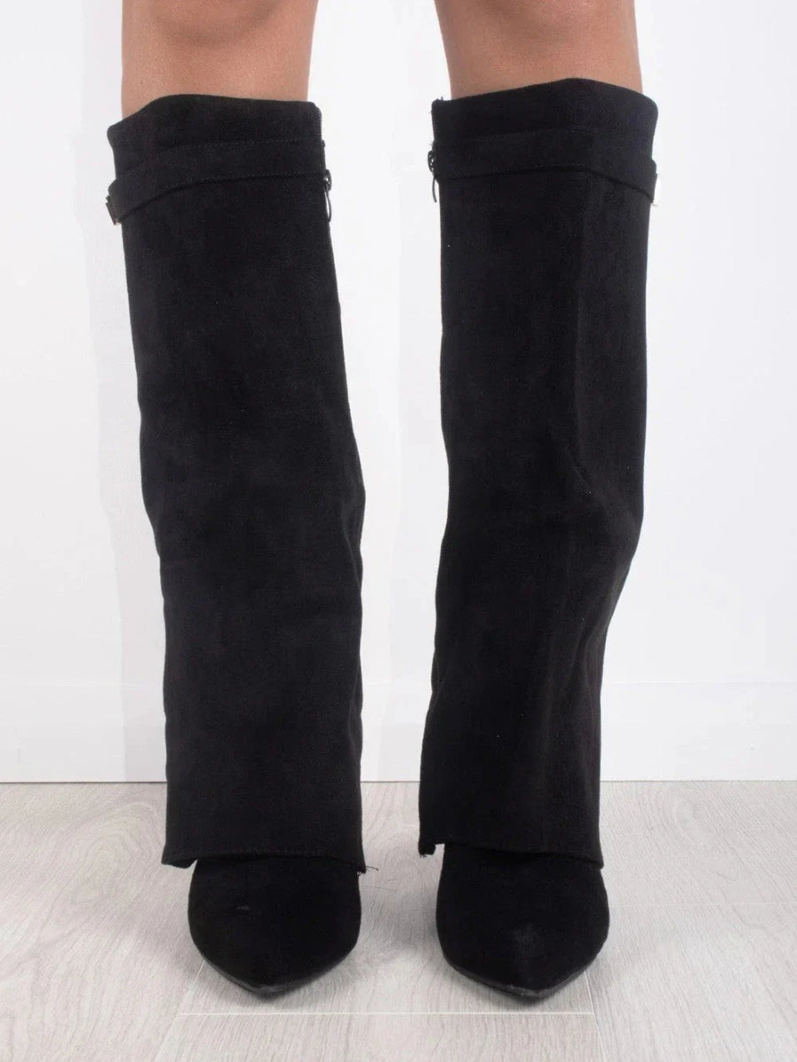 Vue de face des bottes noires en daim avec rabat sur le pied, portées par une femme sur fond clair. 3