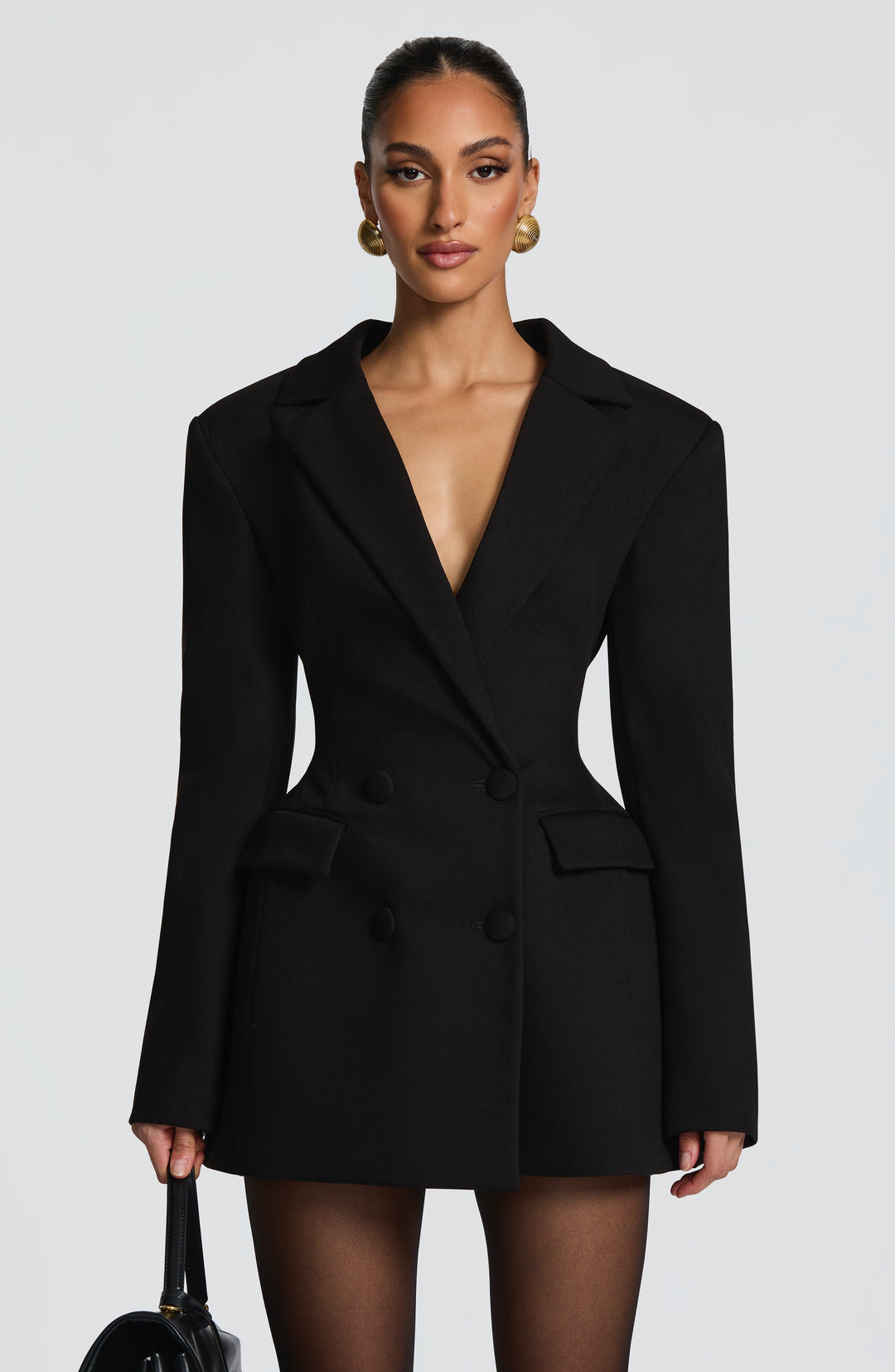 Vue de face de la robe blazer noire, double boutonnage, poches à rabat, taille marquée et large décolleté en V. 6