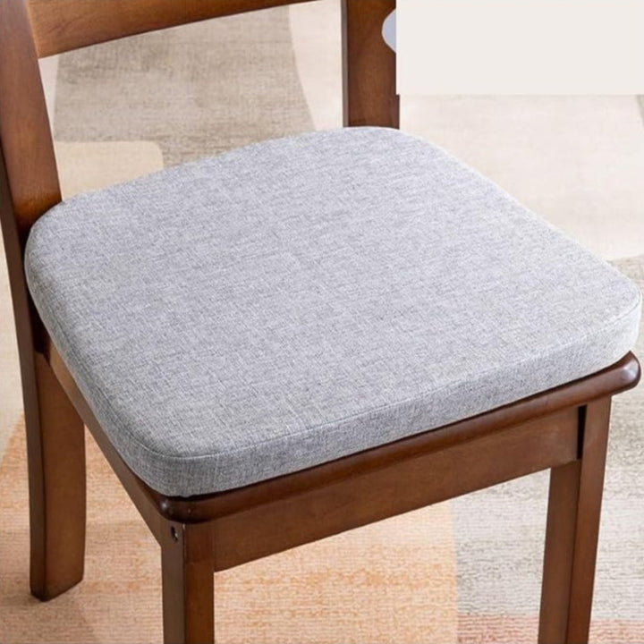 Coussin gris clair chiné à bords arrondis installé sur une chaise en bois 2