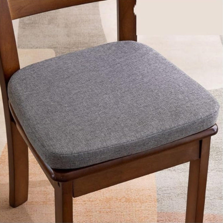 Coussin gris foncé chiné aux coins arrondis posé sur l'assise d'une chaise en bois 3