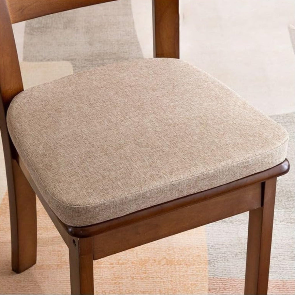 Coussin beige taupe chiné posé sur une chaise en bois, sur un tapis clair 5