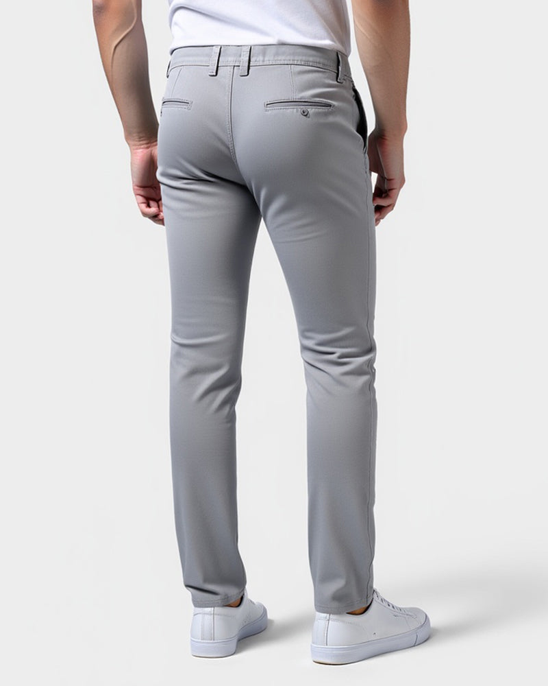 Chino gris clair vu de dos sur un modèle, avec poches arrière passepoilées et passants de ceinture, baskets blanches. 3