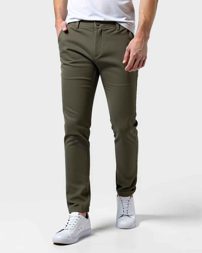 Chino vert kaki porté de face avec un t-shirt blanc, une main dans la poche et des baskets blanches. 13