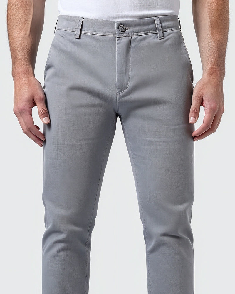 Gros plan sur la taille du chino gris clair : bouton, fermeture sur le devant et passants de ceinture. 5