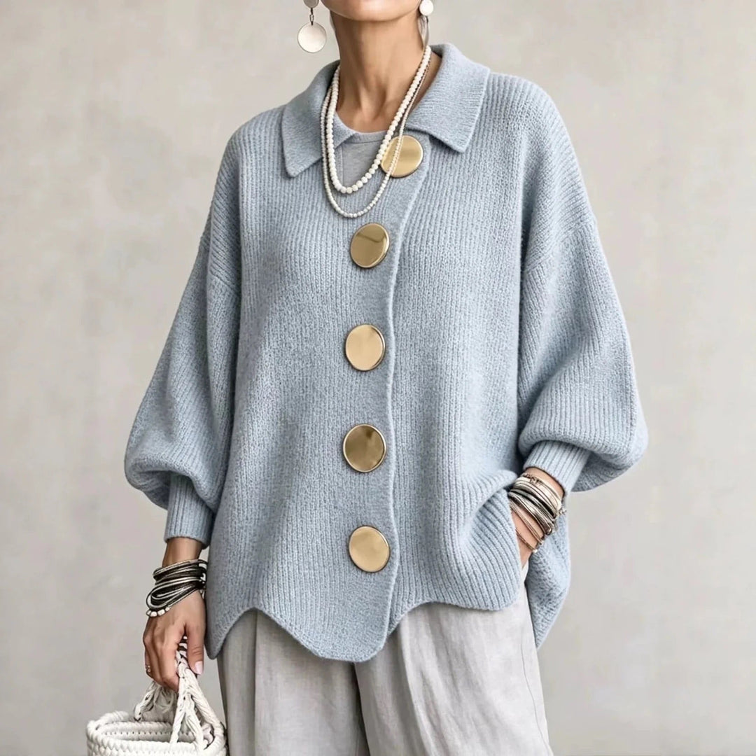 Cardigan bleu ciel en maille côtelée à gros boutons dorés, porté avec un pantalon gris clair. 5