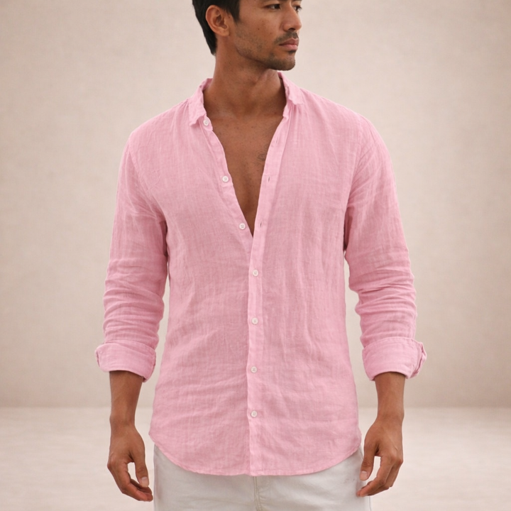Homme portant la chemise en lin rose, boutonnée en partie, manches retroussées, vue de face avec un pantalon blanc. 1
