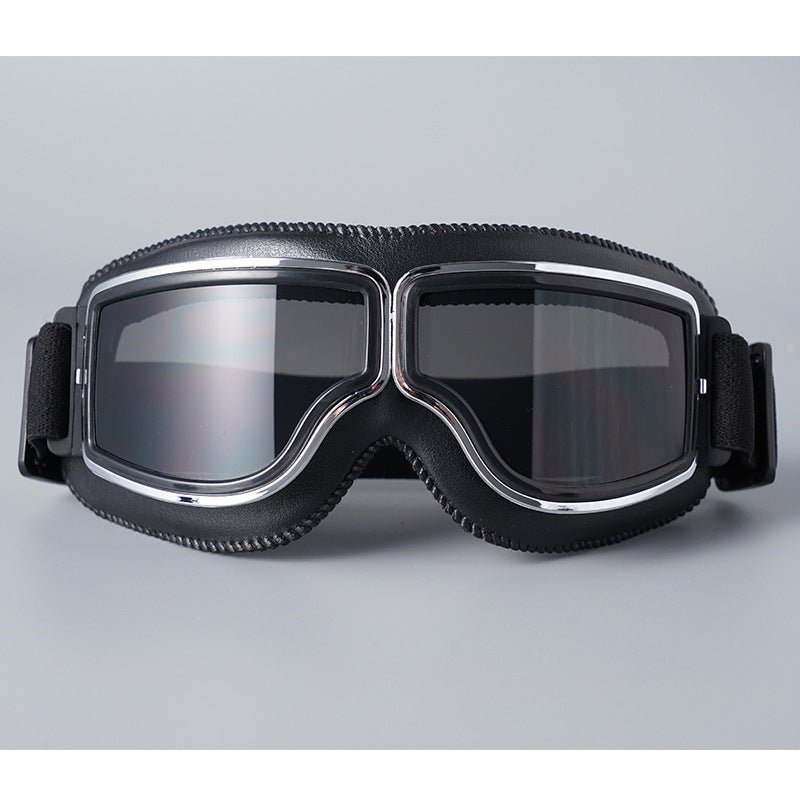 Lunettes à contour noir et monture chromée avec verres fumés gris, sangle élastique noire, vues de face sur fond gris. 5