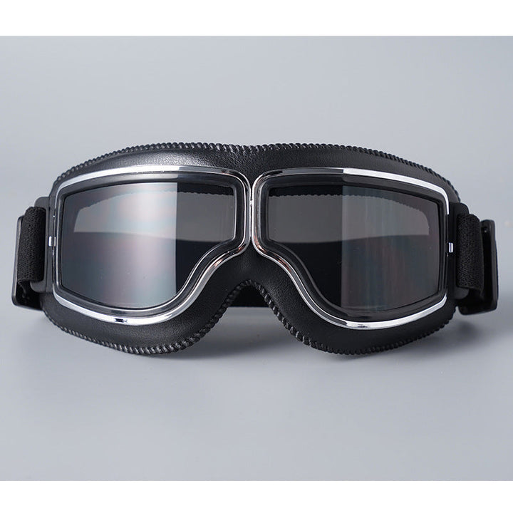 Lunettes à contour noir et monture chromée avec verres fumés gris, sangle élastique noire, vues de face sur fond gris. 5