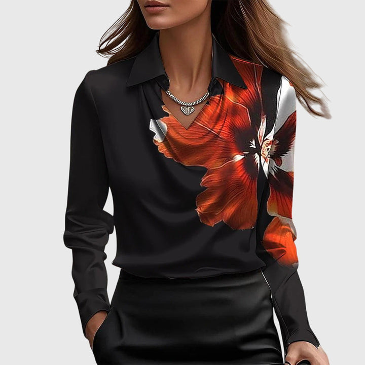 Blouse noire à col drapé ornée d'une grande fleur orange et blanche imprimée sur l'épaule et la poitrine. 6