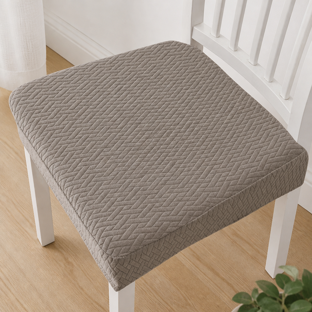 Vue de dessus d'une housse d'assise taupe Ă  motif de chevrons en relief sur une chaise blanche. 12
